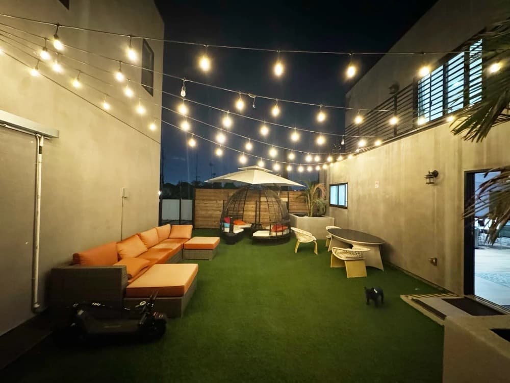 Outdoor lounge area at night with string lights